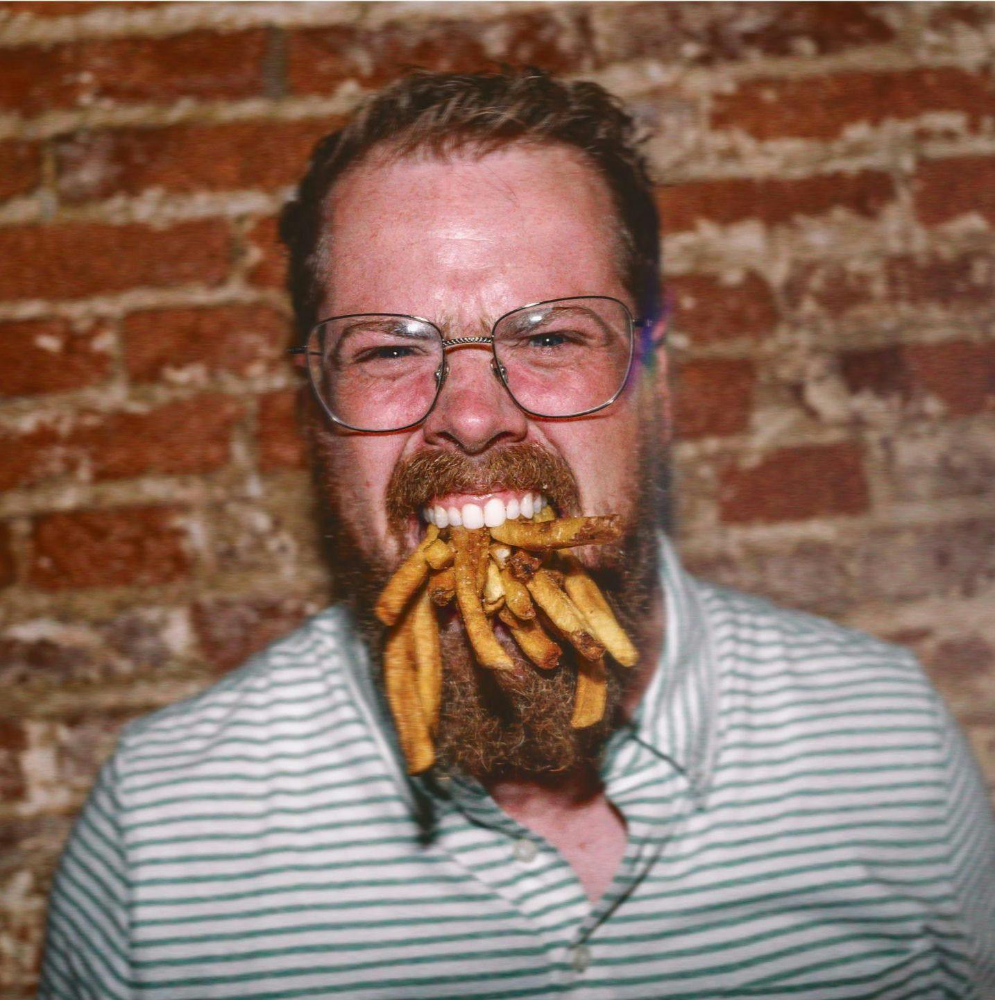 Man with fries in mouth