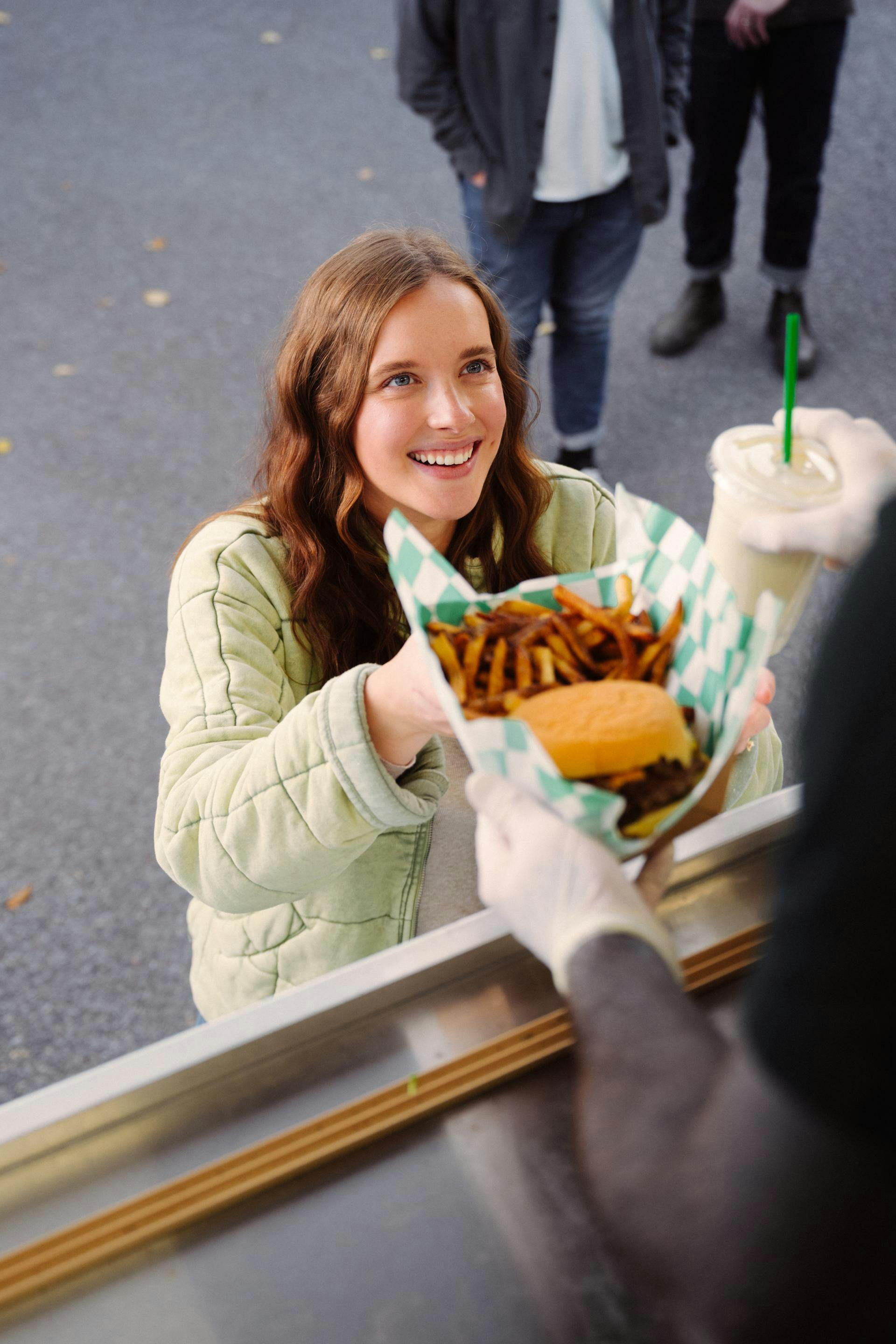 A girl being served a burger
